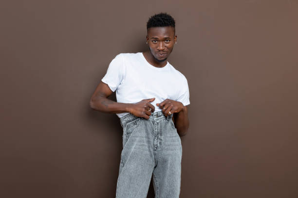 istock African descent black man posing awkwardly in front of brown wall looking at camera. 1450776055