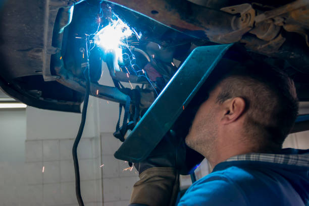istock Skilled welder with mask doing the welding in a workshop.During the welding, there were a lot of sparks from the iron bar. 1450776594