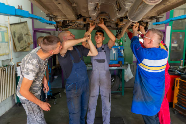istock Male tutor with students on auto mechanic apprenticeship course at college 1450785712