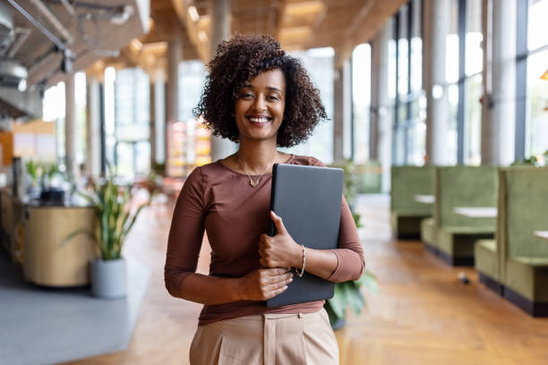 портрет счастливой африканской бизнесвумен, держащей цифровой планшет в офисе - front view фотографии стоковые фото и изображения
