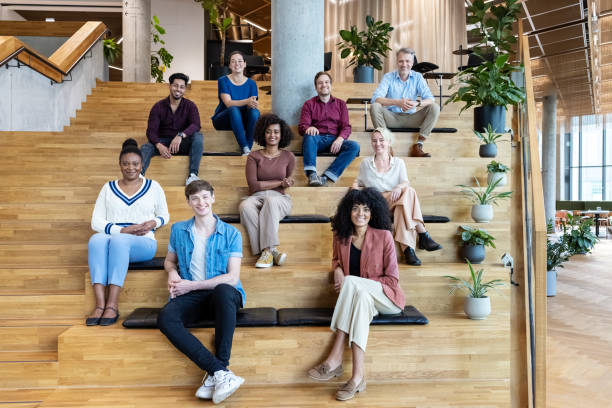 Portrait of multiracial business team sitting together on steps Portrait of multiracial business team sitting together on steps. Diverse business group at a conference. publicity event stock pictures, royalty-free photos & images
