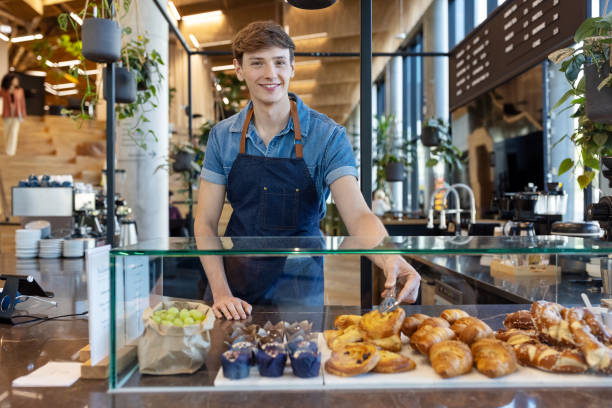 Cafe worker serving pastry at counter stock photo