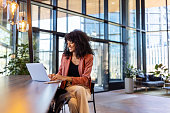 Young African woman working on laptop at office cafe