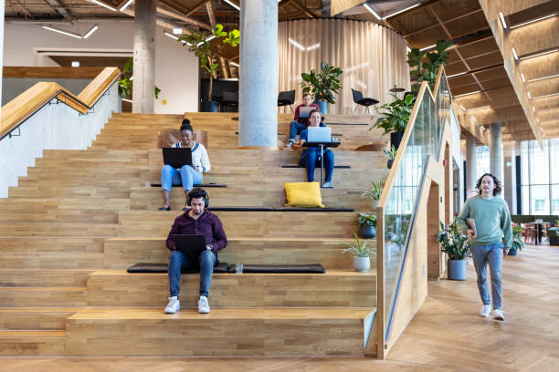 istock Multiracial businesspeople sitting on steps and working at creative office 1450789049