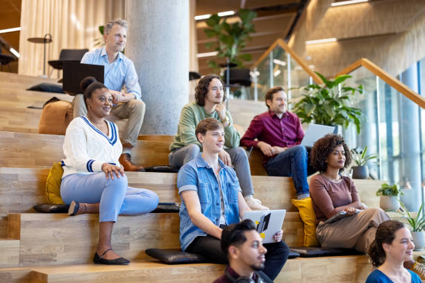 istock Professionals sitting on steps during meeting at creative office 1450789122