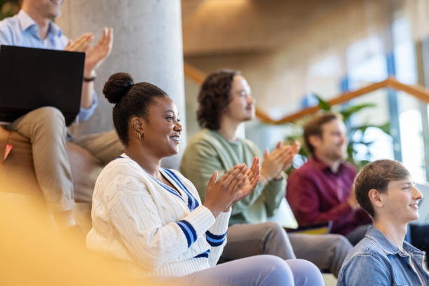 istock Multi-ethnic group of people sitting on steps clapping hands during a conference 1450789141