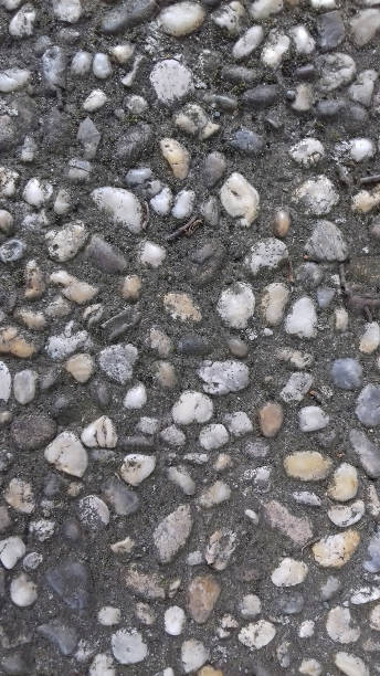 istock Background image with little white and gray stones implanted in pavement. 1450789231