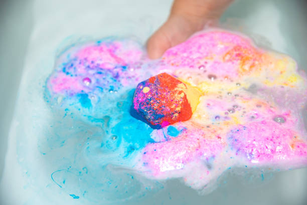 istock Multicolored bath bomb being submerged into water with a hand 1450789341
