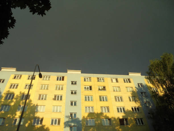 istock Contrasting image of sunlight covered building under dark storm cloud 1450789364