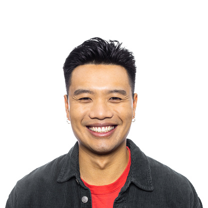 Close-up portrait of smiling asian man looking at camera. Happy male in casuals on white background.