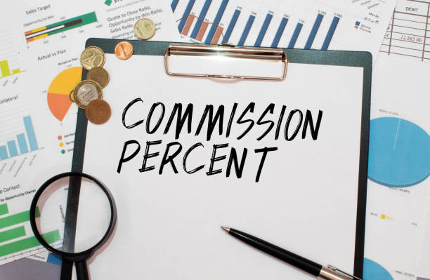 istock text Commission Percent written on white paper sheet with hundred dollar bills. 1450795033