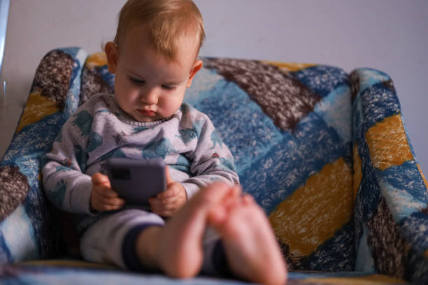 istock Baby looking at the smartphone 1450797050