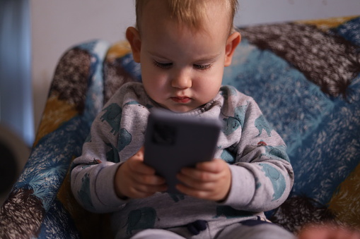 Concentrated little boy using smart phone