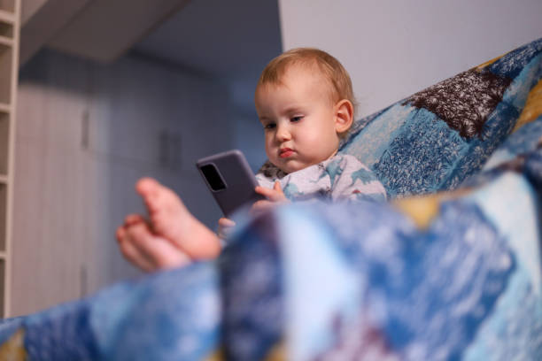 istock Baby looking at the smartphone 1450797710