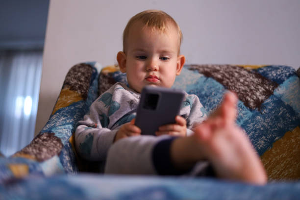 istock Baby looking at the smartphone 1450797724