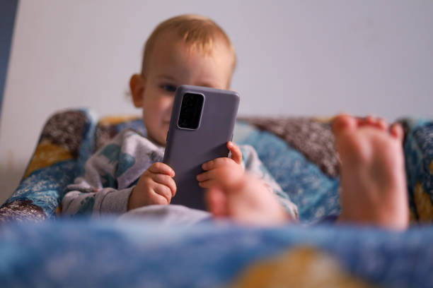 istock Baby looking at the smartphone 1450797758