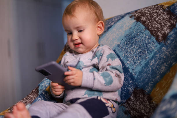 istock Baby looking at the smartphone 1450797772