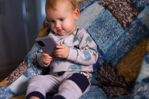 istock Baby looking at the smartphone 1450797773