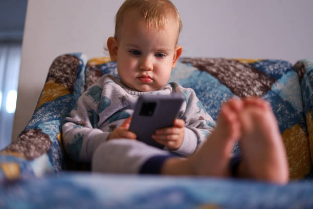 istock Baby looking at the smartphone 1450798308