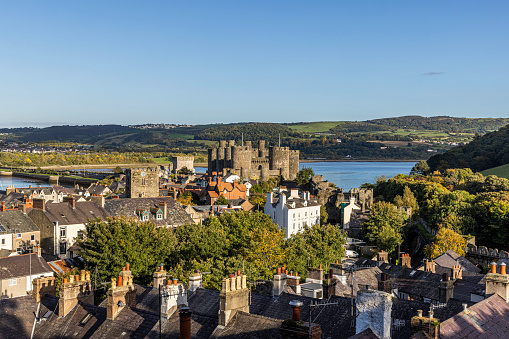 Aerial view of walled market town of Conwy with Conwy Castle in the background, Conwy County Borough in North Wales, UK. The walled town stands on the west bank of the River Conwy, facing Deganwy on the east bank.