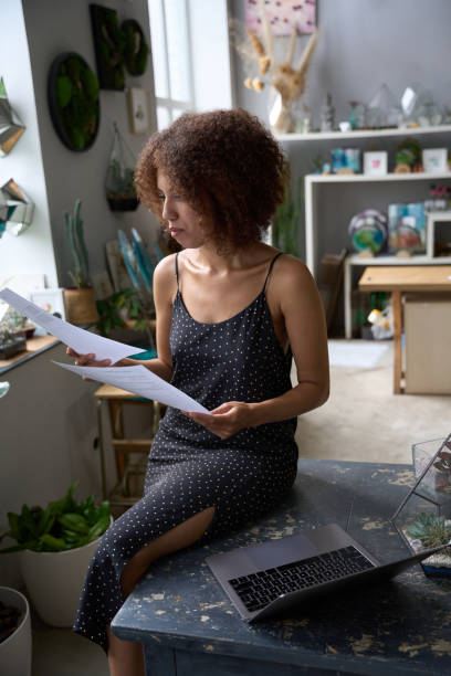 istock Focused young woman looking at paperwork at home 1450804048