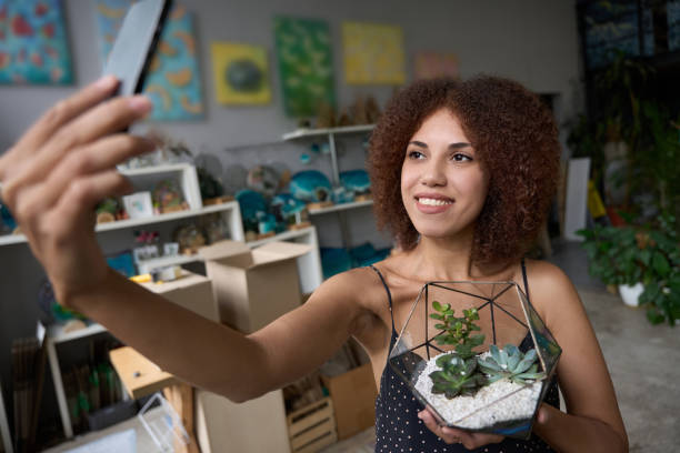 istock Successful young female florist posing for a selfie with plants 1450804101