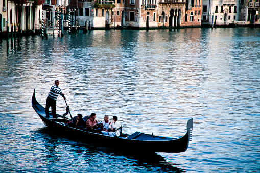 Venice, Italy -August 08, 2022: Tourist enjoying a gondola excursion along The Grand Canal.