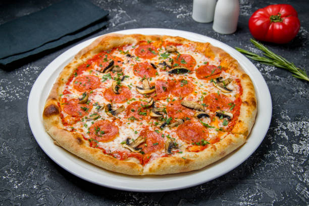 istock Pepperoni pizza with mushrooms on dark table 1450809589