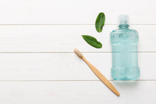 istock Mouthwash and fresh mint on colored background, top view with copy space for text 1450809734