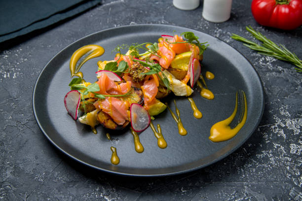 istock mixed salad with salmon, potatoes and artichokes on black plate 1450809833