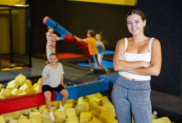 Photo of Young girl standing near foam pit in inflatable playground