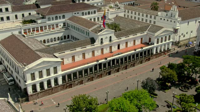 Footage of the city of Quito in Ecuador with the country's flag waving on the roof and a crowdy city