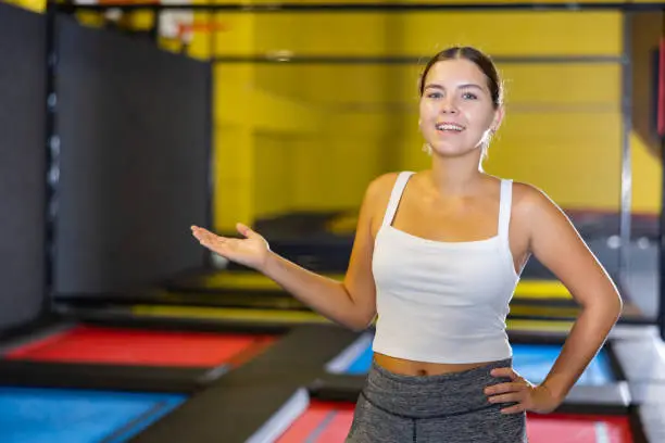 Photo of Woman trampolining coach against the background of children playing and jumping on a trampoline