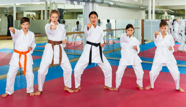 istock Female trainer is training teenagers in karate class 1450811600