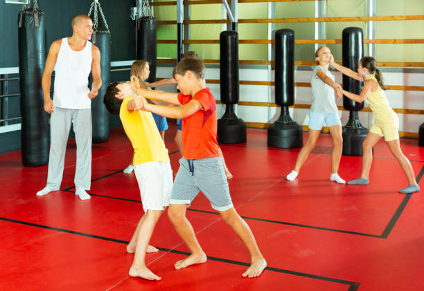 istock Kids exercising chin strike in gym 1450811646