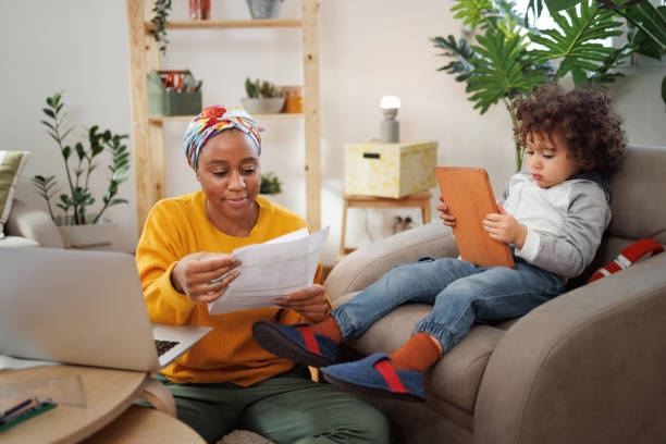 istock Mother working from home while her cute little son is using digital tablet next to her 1450811823