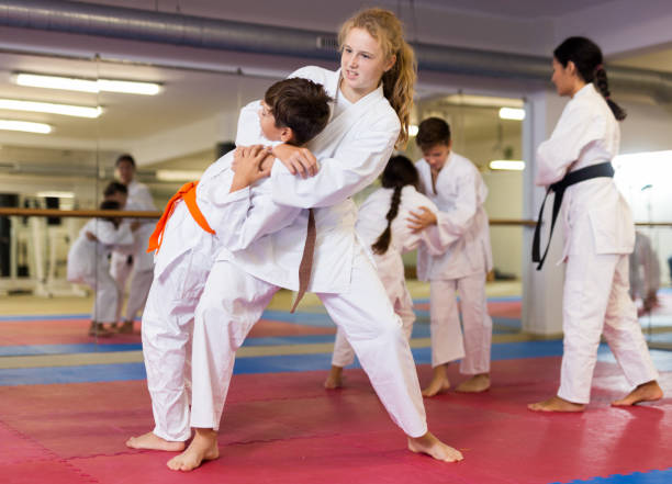 istock Girl doing throw over her shoulder at self-defense lesson 1450812377