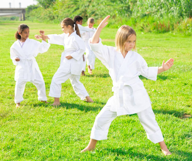istock Preteen girl practicing karate with group in summer park 1450812477