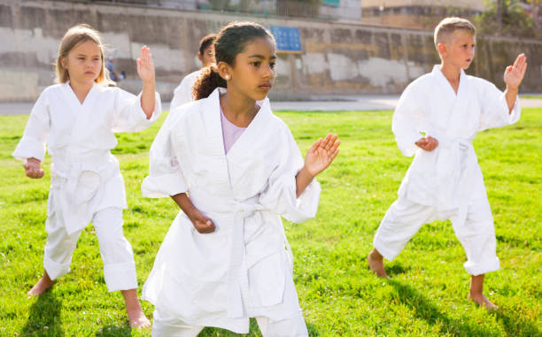 istock Positive children practicing karate in park 1450812707