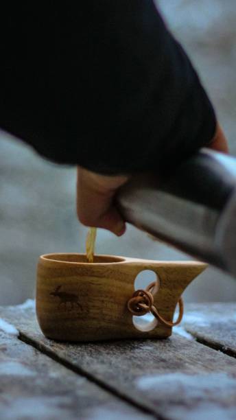 istock Man pouring tea on a nordic wooden mug 1450814201