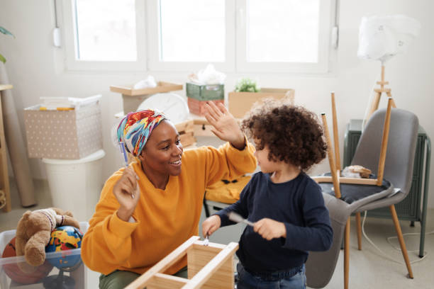 istock Mother and son having fun while assembling furniture in their new apartment 1450814247