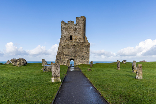 Ruins of medieval stone Christian church called Temple Melaghlin in Clonmacnoise in Ireland. The ancient monastic city of Clonmacnoise with the typical crosses and graves