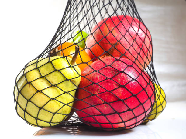 istock fresh fruit pomegranates persimmon pepper In a mesh bag black string bag 1450838710