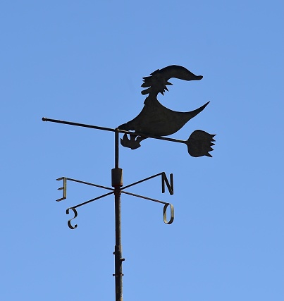 plain modern weathervane on a roof top showing wind direction without a cockerel