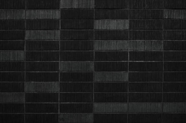 istock Black uneven antique brick wall background 1450860895
