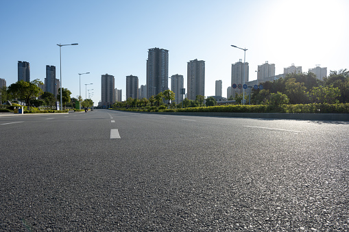 Empty road in front of city buildings