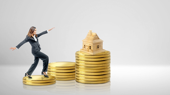 Asian businesswoman climbing coin stairs to get wealth with white background