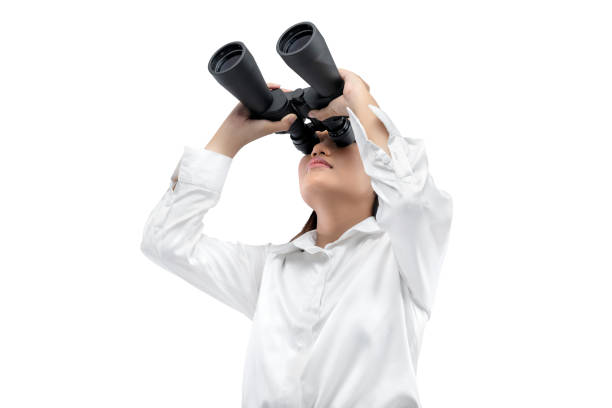 Asian businesswoman looking through binoculars isolated over white background