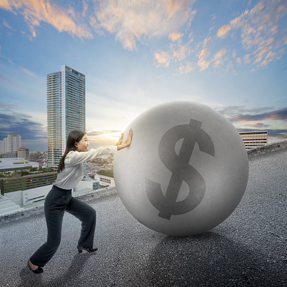 Asian businesswoman pushing money on the street with the background of a cityscape