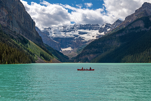 Lake Louise and Victoria glacier with unrecognizable people on kayak, Banff national park, Alberta, Canada.